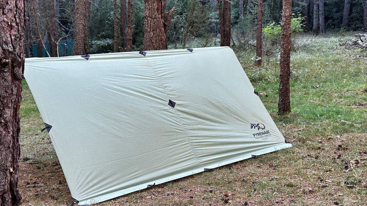 Pyrenaik Apex Tarp desplegado como refugio entre los árboles